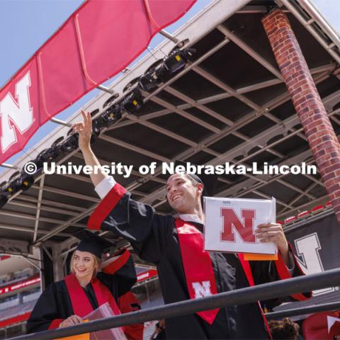 Brett Gaffney waves to his family and friends in Memorial Stadium after receiving his diploma. UNL undergraduate commencement in Memorial Stadium. May 14, 2022. Photo by Craig Chandler / University Communication.