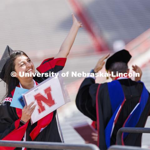 Sifat Syed shows off her college of Engineering diploma to friends and family. UNL undergraduate commencement in Memorial Stadium. May 14, 2022. Photo by Craig Chandler / University Communication.