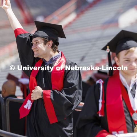 Anthony Wynegar shows off his college of Engineering diploma to friends and family. UNL undergraduate commencement in Memorial Stadium. May 14, 2022. Photo by Craig Chandler / University Communication.