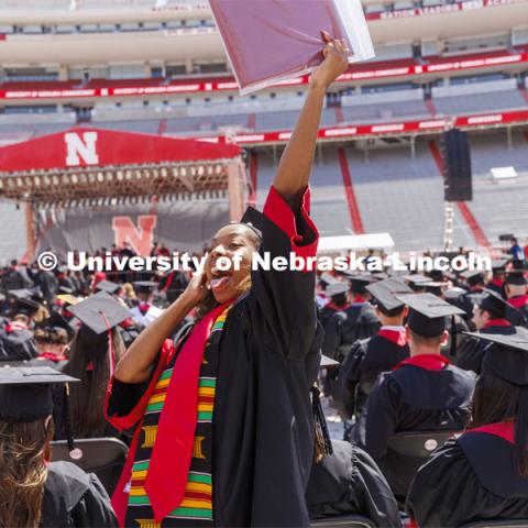 Cherish Perkins, senior in fashion merchandising with minors in international studies, art, and business, waves to her family as she returns to her seat after receiving her diploma. UNL undergraduate commencement in Memorial Stadium. May 14, 2022. Photo by Craig Chandler / University Communication.