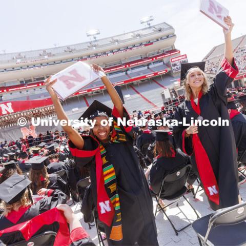 Cherish Perkins and Sydney Petersen wave to her family as they return to her seat after receiving their CEHS diplomas. UNL undergraduate commencement in Memorial Stadium. May 14, 2022. Photo by Craig Chandler / University Communication.