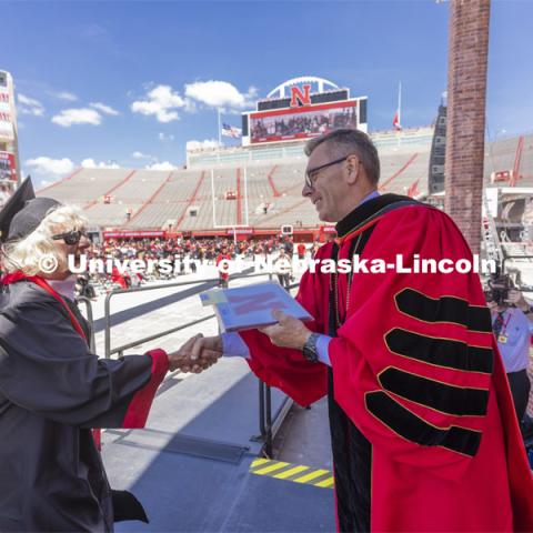 Carol (Dahl Leacox) Livingston receives her diploma from Chancellor Ronnie Green. Livingston finally received her diploma — Bachelor of Science in Business Administration — for her studies at the University of Nebraska-Lincoln from 1955-59. UNL undergraduate commencement in Memorial Stadium. May 14, 2022. Photo by Craig Chandler / University Communication.