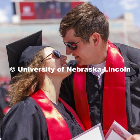 Maria Harthoorn and Jordan Popp share a kiss following commencement. Their summer plans are to marry in two weeks. UNL undergraduate commencement in Memorial Stadium. May 14, 2022. Photo by Craig Chandler / University Communication.