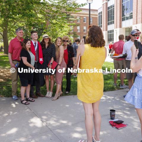 Braden Fink and family pose for photos following the UNL undergraduate commencement in Memorial Stadium. May 14, 2022. Photo by Craig Chandler / University Communication.