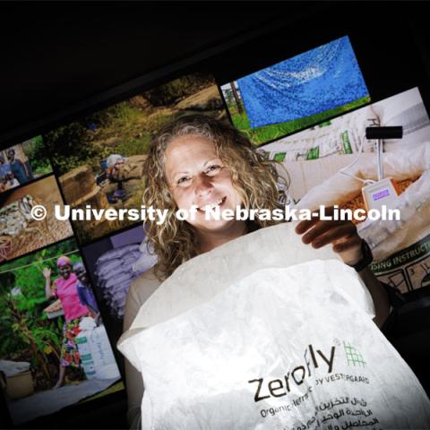 Georgina Bingham, research associate professor of entomology at Nebraska, holds an airtight, insect-resistant storage bag known as a ZeroFly® Hermetic bag with insecticide incorporated to prevent damaging pest infestations. She led the development of the bags while working for the Swiss company Vestergaard. It reduces the loss of seeds or grains that can be consumed, stored for security, or sold for optimized prices. It is said to be free of the hazards associated with fumigation or the potential for pesticide residues that come from inaccurate insecticide spraying. The insecticide is incorporated into individual fibers of the bags, which provides a killing action before insects can infest the grain or seed packed in the bag a bag. May 26, 2022. Photo by Craig Chandler / University Communication.