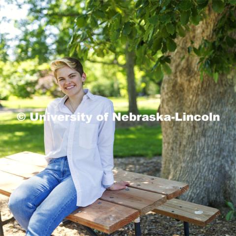 Ally Barry, a junior in environmental studies, sits in the arboretum on East Campus, one of her favorite places on campus.  Photo for her PRIDE month feature story. June 3, 2022. Photo by Craig Chandler / University Communication. 