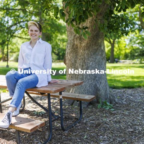 Ally Barry, a junior in environmental studies, sits in the arboretum on East Campus, one of her favorite places on campus.  Photo for her PRIDE month feature story. June 3, 2022. Photo by Craig Chandler / University Communication. 