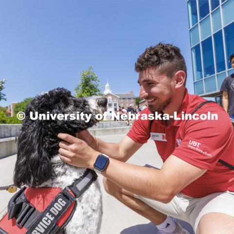 Hershey receives plenty of attention from NSE students outside the Cather Dining Center. Hershey is a 1 1/2 year old labradoodle being trained as a therapy dog. He will be part of the UNL Police Department this fall. June 17, 2022. Photo by Craig Chandler / University Communication.