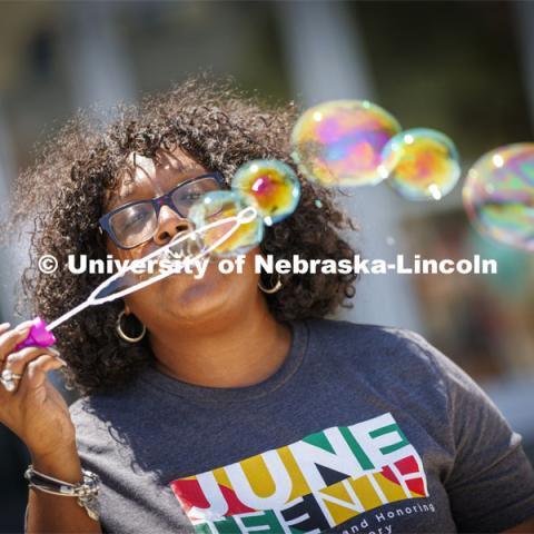 Charlie Foster, Assistant Vice Chancellor for Inclusive Student Excellence and Director of the Office of Academic Success and Intercultural Services, blows a series of bubbles across the Nebraska Union Plaza during the university’s inaugural celebration of Juneteenth. Juneteenth, the federal holiday that commemorates the emancipation of enslaved Black Americans, is celebrated in an event starting at noon on the Nebraska Union Plaza. June 20, 2022. Photo by Craig Chandler / University Communication.