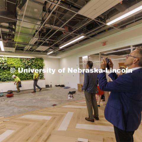 Chancellor Ronnie Green takes a photo of a living wall in the new wellness area of the law library. The hydroponic wall is made of living plants. Green and donors take a tour of the renovated College of Law library. The $6 million renovation of the Marvin and Virginia Schmid Law Library began in May 2021 will be open in the fall. The project will provide new and rejuvenated spaces for the community. June 22, 2022. Photo by Craig Chandler / University Communication.