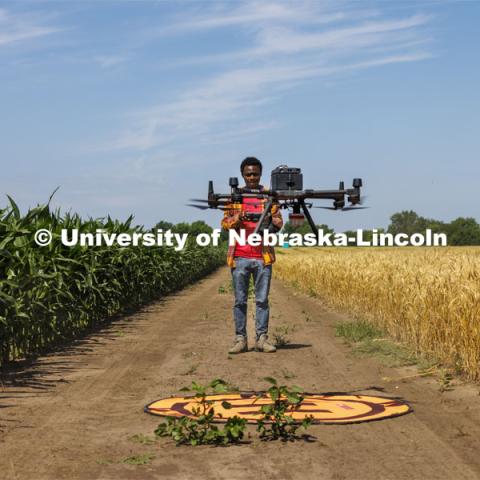 Pascal Izere, master’s student in Biological Systems Engineering, launches an autonomous drone photographing a field of triticale at the research fields at 84th and Havelock. Biological Systems Engineering fieldwork with drones for phenotyping fields. June 27, 2022. Photo by Craig Chandler / University Communication.