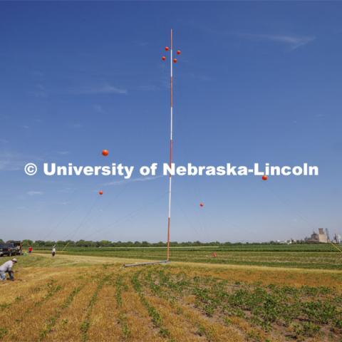 A tower goes up at the UNL 84th and Havelock fields for Benjamin Riggan, assistant professor of electrical and computer engineering. He is part of a team of researchers from across the country participating in a federal government research program to develop software systems capable of performing whole-body biometric identification from long distances and at elevated pitch. June 27, 2022.  Photo by Craig Chandler / University Communication.