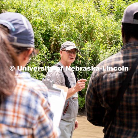 Research Engineer Alan Boldt (center) instructs students on how to measure and record the water flow rates of Salt Creek at Wilderness Park. Irrigation Laboratory and Field Course class trip to Salt Creek at Wilderness Park. July 8, 2022. Photo by Jordan Opp for University Communication.