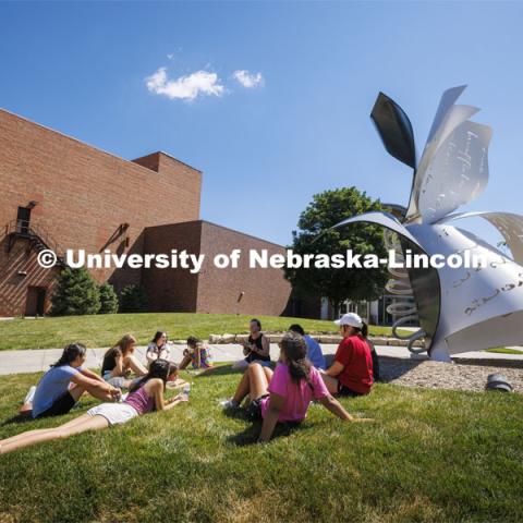 Summer camp students sit on the lawn by the Torn Notebook sculpture. July 12, 2022. Photo by Craig Chandler / University Communication.