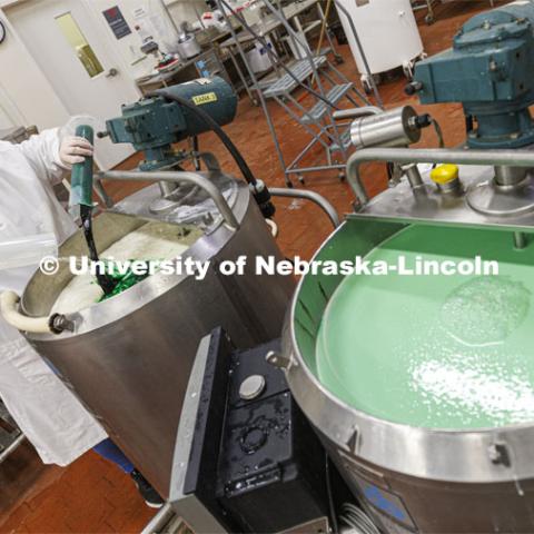 Assistant Dairy Plant Manager Mary Underwood pours in the coloring and flavor for the 100 gallons of Dairy Store 4-H Clover Mint is being made at Food Innovation Center on Nebraska Innovation Campus. July 18, 2022. Photo by Craig Chandler / University Communication.