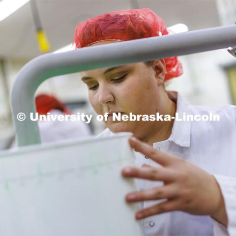 Assistant Dairy Plant Manager Mary Underwood swirls a 3-gallon bucket filling with 4-H Clover Mint being made at the Food Innovation Center on Nebraska Innovation Campus. July 18, 2022. Photo by Craig Chandler / University Communication.