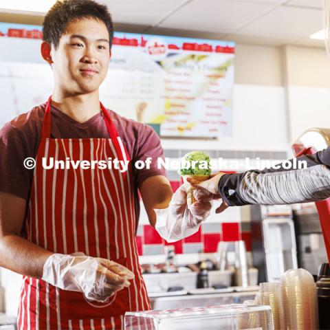 Randy Nguyen serves up a cone of Clover 4-H Mint. Ice cream is scooped up at the Dairy Store on East Campus. July 18, 2022. Photo by Craig Chandler / University Communication.