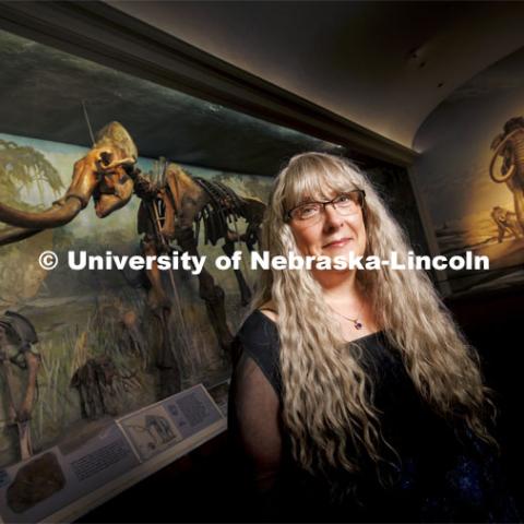 Nebraska’s Kate Lyons, Assistant Professor, School of Biological Sciences, stands in Elephant Hall at the University of Nebraska State Museum. Behind her looms Archie, the largest Columbian mammoth fossil in the world. A study from Lyons and colleagues has found that the extinction of large mammal species, including the Columbian mammoth, likely contributed to the homogenization of North America’s mammal communities. July 22, 2022. Photo by Craig Chandler / University Communication.
