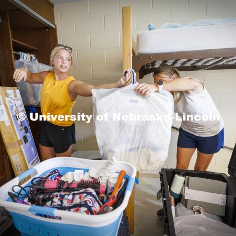 Katie Wemhoff from Grand Island grabs a handful of clothes from her mom, Cindy, as Katie unpacks her possessions. Residence Hall move in for students participating in Greek Rush. August 14, 2022. Photo by Craig Chandler / University Communication.