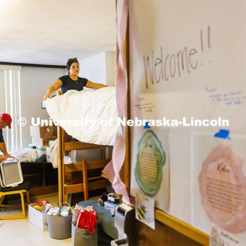 Keah Krings of Hastings makes her bed with her family’s help while her dad works on assembling a rolling shelf unit. Residence Hall move in for students participating in Greek Rush. August 14, 2022. Photo by Craig Chandler / University Communication.