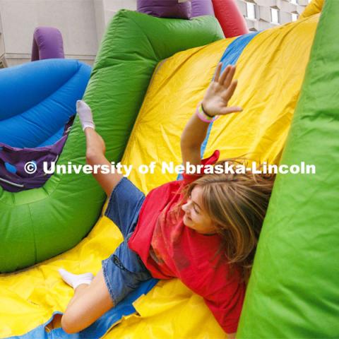 Lila Congrove, a freshman from Noblesville, Indiana, tumbles through the inflatable obstacle course at the Harper Schramm Smith residence halls block party. August 18, 2022. Photo by Craig Chandler / University Communication.