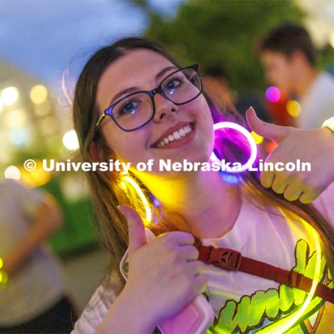 Students pose with their glowing bling at the Harper Schramm Smith residence halls block party. August 18, 2022. Photo by Craig Chandler / University Communication.