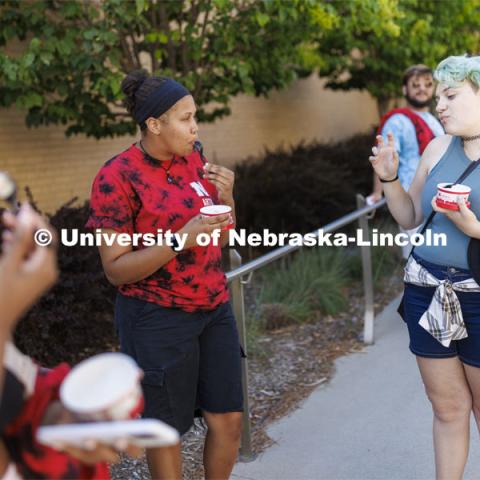 Brannon Evans, a senior from Omaha, left, talks with Rain Sidwell, a freshman from Boulder, Colorado as the two eat Dairy Store ice cream while waiting in line for the food trucks. College Welcomes for new and returning students. Big Red Welcome - College Welcome Programs. August 18, 2022. Photo by Craig Chandler / University Communication.