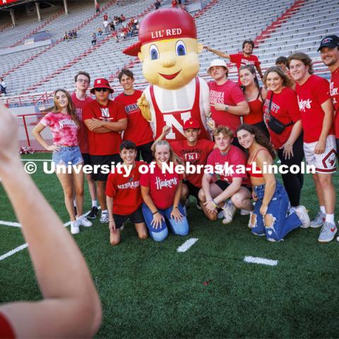 A group of students pose with Lil Red for a picture at the Tunnel Walk and New Student Welcome in Memorial Stadium. August 19, 2022. Photo by Craig Chandler / University Communication.