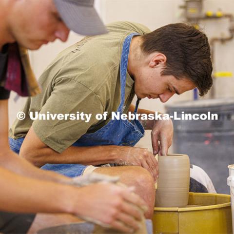 Charlie Floeder, a senior from St. Paul, Minnesota, makes a cylinder during a wheel throwing class in Richards Hall. Students in wheel throwing ceramics class. August 24, 2022. Photo by Craig Chandler / University Communication.