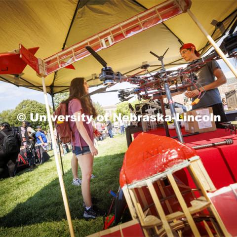 Hayley Hogan, a freshman mechanical engineering student from Lincoln, checks out he drones displayed in one of the engineering club booths. Club Fair in the green space by the Nebraska Union at City Campus. More than 120 recognized student organizations (RSOs) to join for social, professional and leadership interests. RSO members and officers will be on hand to provide details about their organization and answer questions from prospective new members.  August 24, 2022. Photo by Craig Chandler / University Communication.