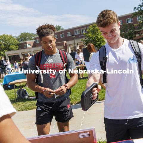 Students test their grip strength at the powerlifting club. Club Fair in the green space by the Nebraska Union at City Campus. More than 120 recognized student organizations (RSOs) to join for social, professional and leadership interests. RSO members and officers will be on hand to provide details about their organization and answer questions from prospective new members. August 24, 2022. Photo by Craig Chandler / University Communication.