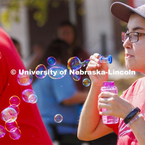 Sarah Roscoe blows bubbles at the UNL Christian Graduate Student club table. Club Fair in the green space by the Nebraska Union at City Campus. More than 120 recognized student organizations (RSOs) to join for social, professional and leadership interests. RSO members and officers will be on hand to provide details about their organization and answer questions from prospective new members. August 24, 2022. Photo by Craig Chandler / University Communication.