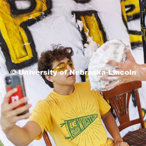 Quinton Chavez videos an incoming pie as he and Acacia Fraternity brothers raise money for Bryan Health. Acacia fraternity held a pie-in-the-face fundraiser for Bryan Health’s new cancer center. All the UNL fraternities are participating and have raised more than $200,000 so far this year. August 25, 2022. Photo by Craig Chandler / University Communication.