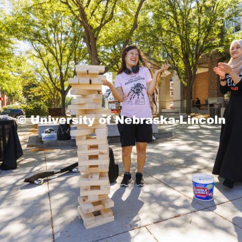 Ayela Ruiz, a freshman from Lincoln, accepts congratulations after making a difficult Jenga move from Hannah Ridzuan (right), a graduate assistant with ODI. ODI at the Union Plaza with activities, treats, and to learn more about the Office of Diversity and Inclusion. August 30, 2022. Photo by Craig Chandler / University Communication.