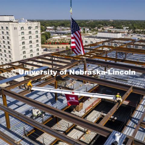 Steel workers move the final beam into place during a construction celebration on Aug. 31. The event signaled the end of steel framing for the $115 million Kiewit Hall build. Kiewit Hall topping off ceremony. August 31, 2022. Photo by Craig Chandler / University Communication.