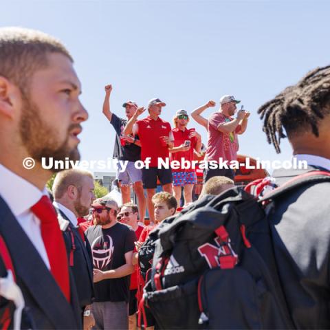 Students stand on the hood of the Bone Yard Bus and cheer as the Huskers walk through the crowd. Student Tailgate and Unity Walk in the Union green space before the game. NU vs. North Dakota. September 3, 2022. Photo by Craig Chandler / University Communication.