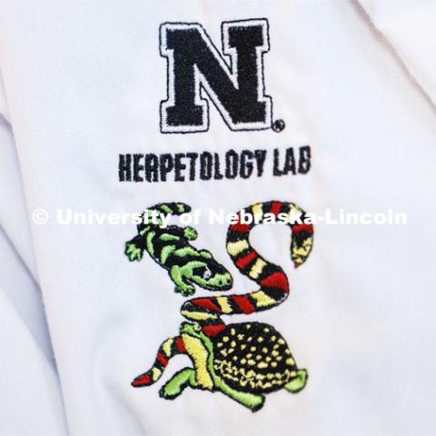 Herpetology logo on a lab coat. A 2-headed garter snake was found in Clay Center, Nebraska.  The snake was transported to Dennis Ferraro’s lab for study. September 8, 2022.  Photo by Craig Chandler / University Communication.