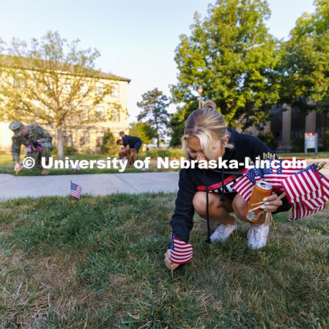 ASUN member Aleks Glowik places a flag on East Campus. The Nebraska Military and Veteran Success Center, ASUN and others placed flags and signs on East Campus today to commemorate 9/11. The display will be moved to city campus on Monday. September 9, 2022. Photo by Craig Chandler / University Communication.