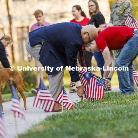 IANR Vice Chancellor and Navy veteran Michael Boehm places a flag on East Campus Friday morning to commemorate Patriot Day. The Nebraska Military and Veteran Success Center, ASUN and others placed flags and signs on East Campus today to commemorate 9/11. The display will be moved to city campus on Monday. September 9, 2022. Photo by Craig Chandler / University Communication.