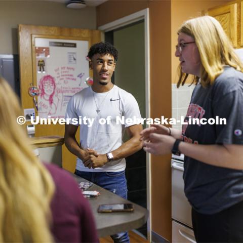 Students socializing in an apartment style room in The Courtyards Residence Hall. Housing Photo Shoot in The Courtyards Residence Hall. September 27, 2022. Photo by Craig Chandler / University Communication.