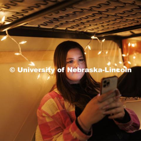 A student takes a selfie under her bunkbed in her Couryard Residence Hall room. Housing Photo Shoot in The Courtyards Residence Hall. September 27, 2022. Photo by Craig Chandler / University Communication.