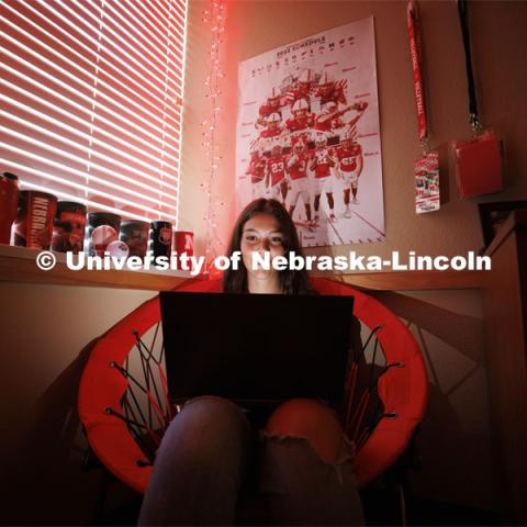 A student studies by the glow of red christmas lights in their University Suites Residence Hall room. Housing Photo Shoot in University Suites Residence Hall. September 27, 2022. Photo by Craig Chandler / University Communication.