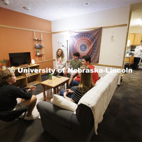 Students socializing in a University Suites Residence Hall room. Housing Photo Shoot in University Suites Residence Hall. September 27, 2022. Photo by Craig Chandler / University Communication.