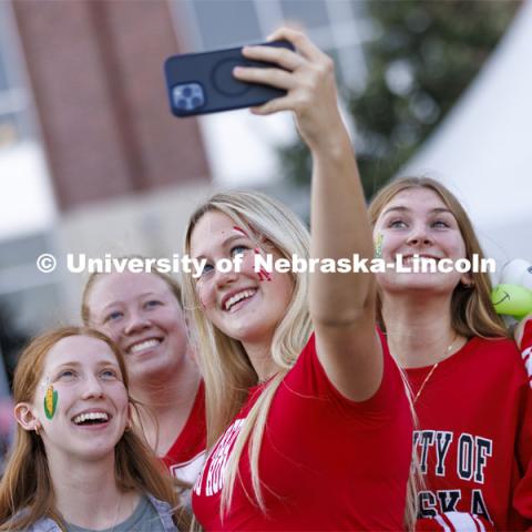 Students pose for a selfie at the Homecoming Parade and Cornstalk. September 30, 2022. Photo by Craig Chandler / University Communication.