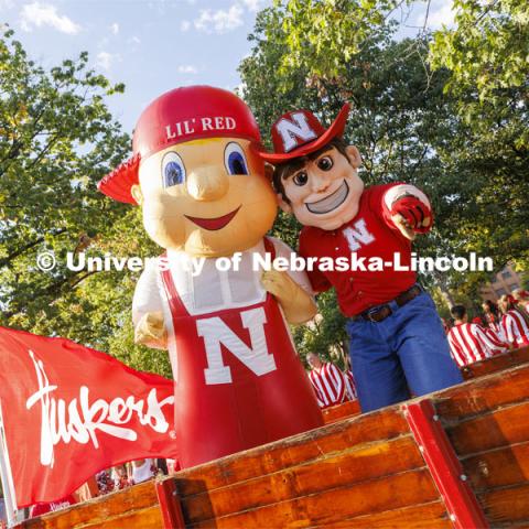 Herbie Husker and Lil’ Red in a trailer pulled by Jake Jundt a former Husker Cheer squad member and current assistant with the team. Jundt pulled the trailer with an antique International Harvester tractor his family owns. Homecoming Parade and Cornstalk. September 30, 2022. Photo by Craig Chandler / University Communication.