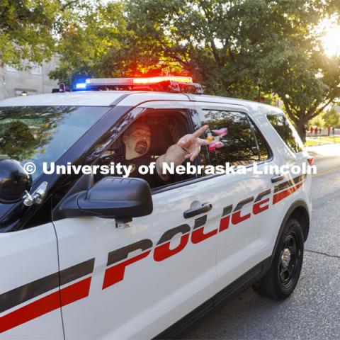 Captain Aaron Pembleton throws candy to spectators as the UNLPD leads the homecoming parade. Homecoming Parade and Cornstalk. September 30, 2022. Photo by Craig Chandler / University Communication.