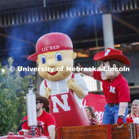 Lil’ Red and Herbie Husker wave to the crowd in from of the stadium. Homecoming Parade and Cornstalk. September 30, 2022. Photo by Craig Chandler / University Communication.