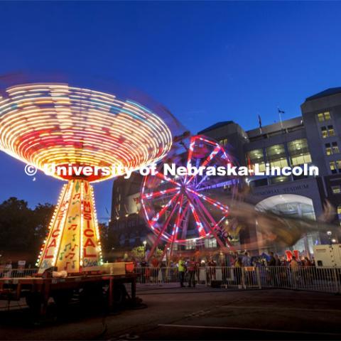 The Musical Chairs ride and the Ferris Wheel were spinning in a long exposure after the sun set Friday night. Homecoming Parade and Cornstalk. September 30, 2022. Photo by Craig Chandler / University Communication.