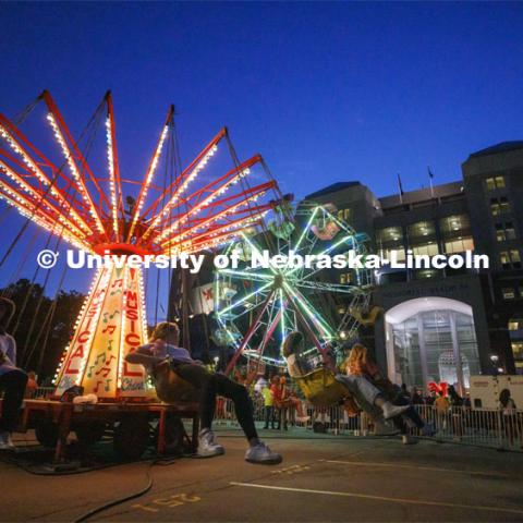 The Musical Chairs ride and the Ferris Wheel lighted up the east stadium parking lot Friday night. Homecoming Parade and Cornstalk. September 30, 2022. Photo by Craig Chandler / University Communication.
