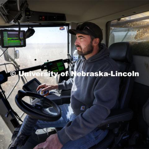 Surrounded by acres of popcorn outside his combine cab and multiple computer monitors inside the cab, Andrew McHargue harvests popcorn east of Chapman, Nebraska. Preferred Popcorn grows popcorn near Chapman, Nebraska and throughout the area. It is headed by Norm Krug. October 13, 2022. Photo by Craig Chandler / University Communication.